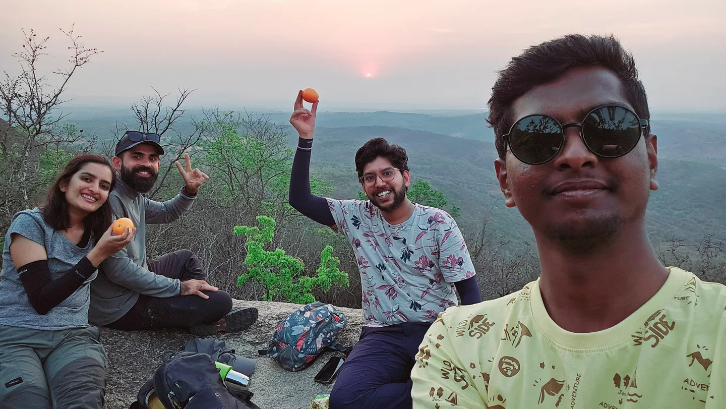 The four of us on the big rock at the Halu Chilume Gange viewpoint, with the sun setting over the hills