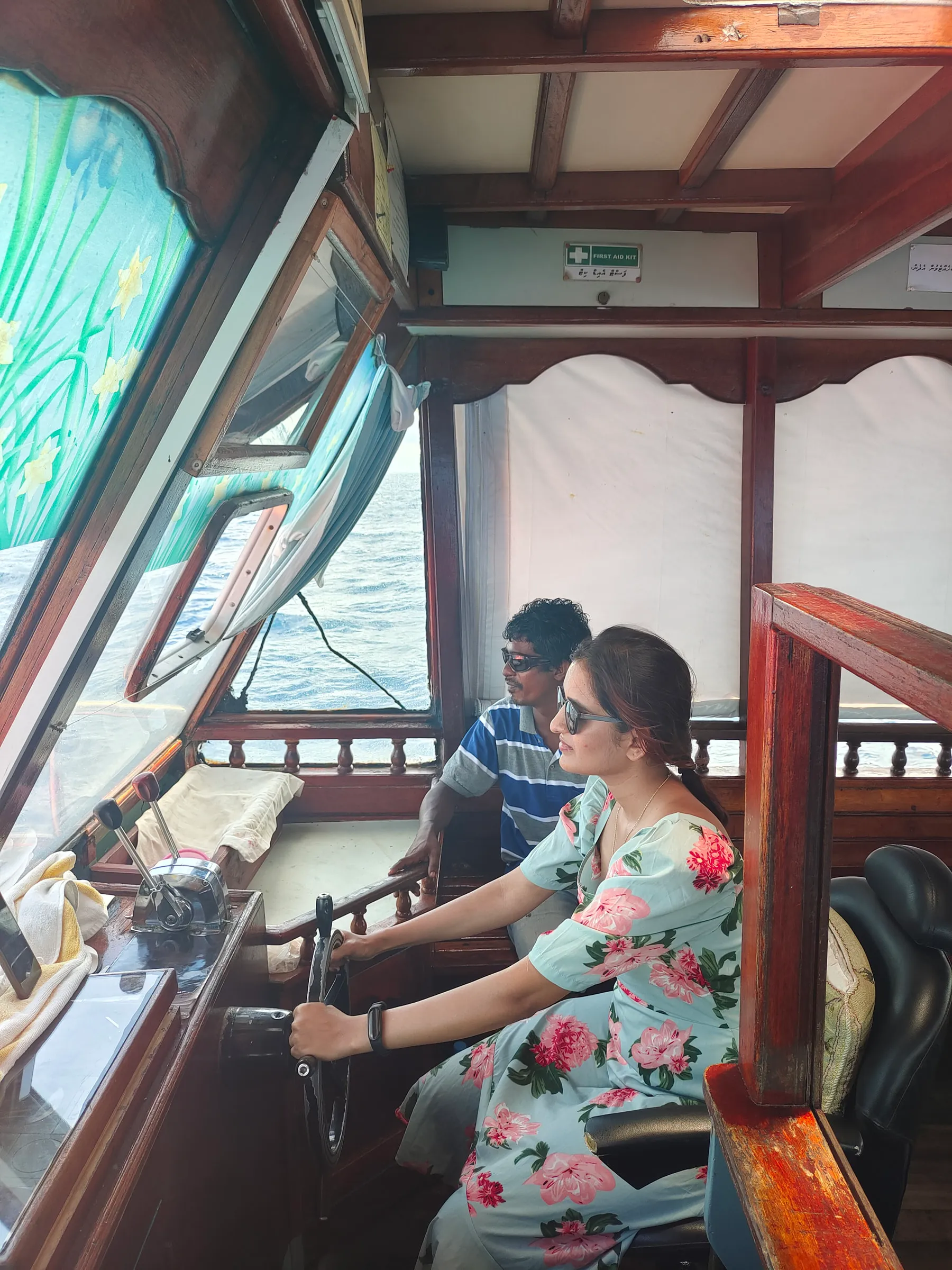 Apoorva steering the local ferry from Fulidhoo to Keyodhoo, with the captain beside her